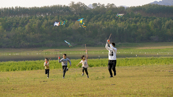 黄振国带孩子到大草坪放风筝。