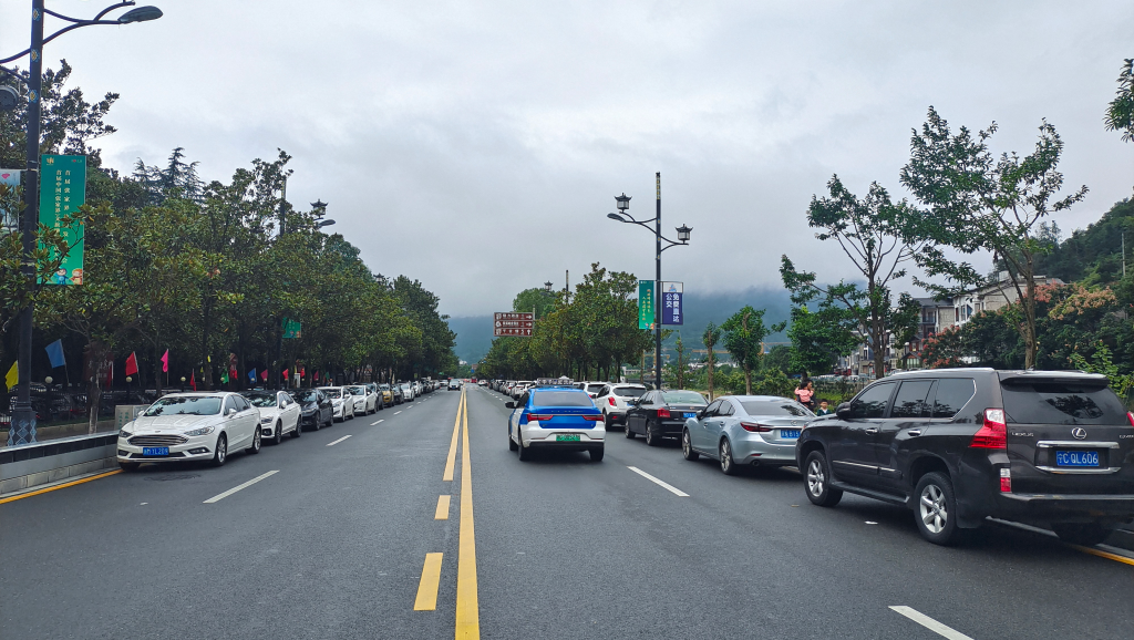 在不影响交通的前提下，车辆有序停放在武陵源城区道路旁边。（吴勇兵摄）