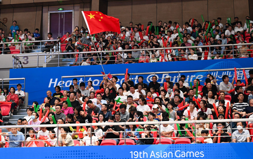 10月1日，一名观众在杭州亚运会篮球比赛现场挥舞五星红旗为参赛选手加油。新华社记者 杨冠宇 摄