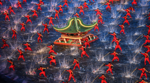 开幕式文体展演第二章《同心同缘》,棍术表演者踏入中央水域,粼粼波光映照着翻飞的棍影,光影交错,气势如虹。图源:新华社 开幕式文体展演第二章《同心同缘》,棍术表演者踏入中央水域,粼粼波光映照着翻飞的棍影,光影交错,气势如虹。图源:新华社