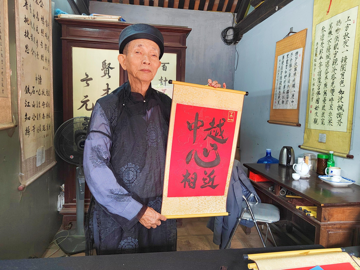 2023年12月9日，越南首都河内文庙内，越南书法家阮明珠展示“中越心相近”书法作品。新华社记者 郑开君 摄