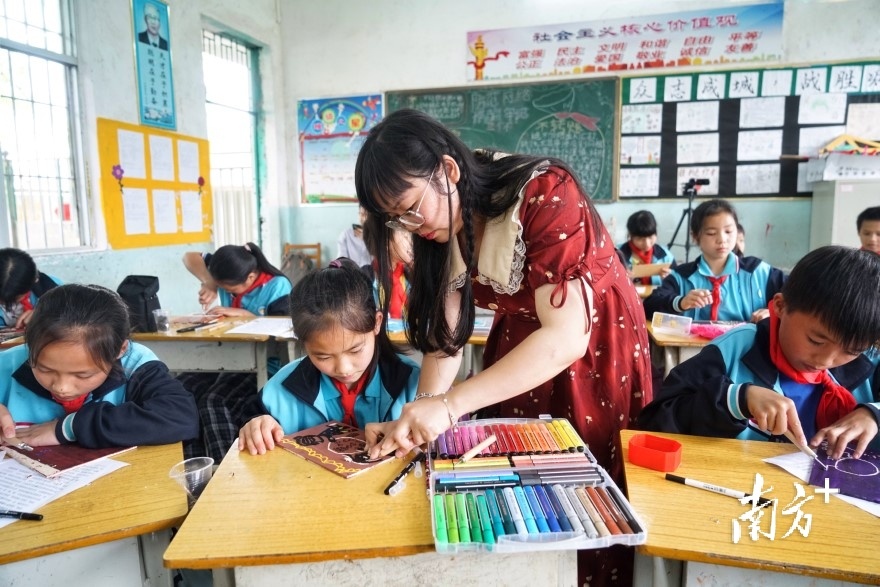 南楼小学美术课堂上，邵晓玲指导学生作画。梁素雅 摄