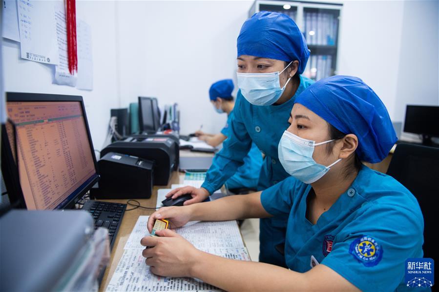 　　在湖南省人民医院ICU病房护士站，徐芙蓉（中）和同事查看病人住院记录（2022年9月9日摄）。新华社记者 陈思汗 摄