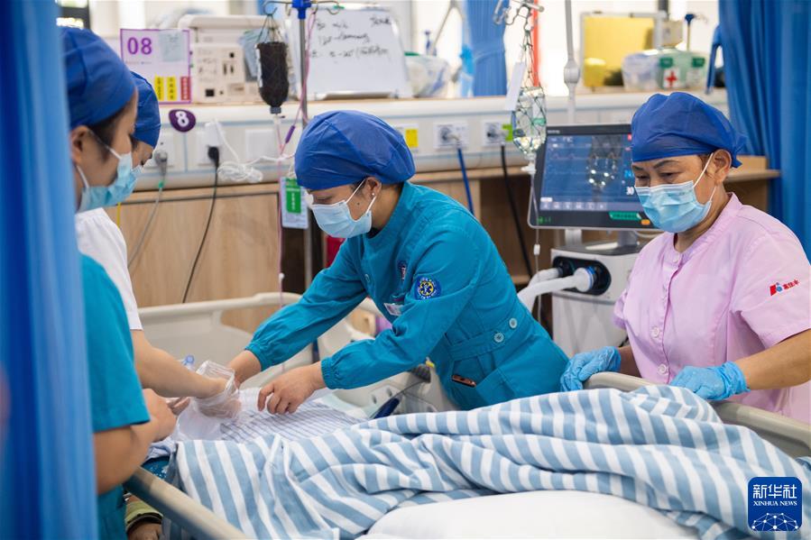 　　在湖南省人民医院ICU病房，徐芙蓉（中）和同事在给病人做护理（2022年9月9日摄）。新华社记者 陈思汗 摄