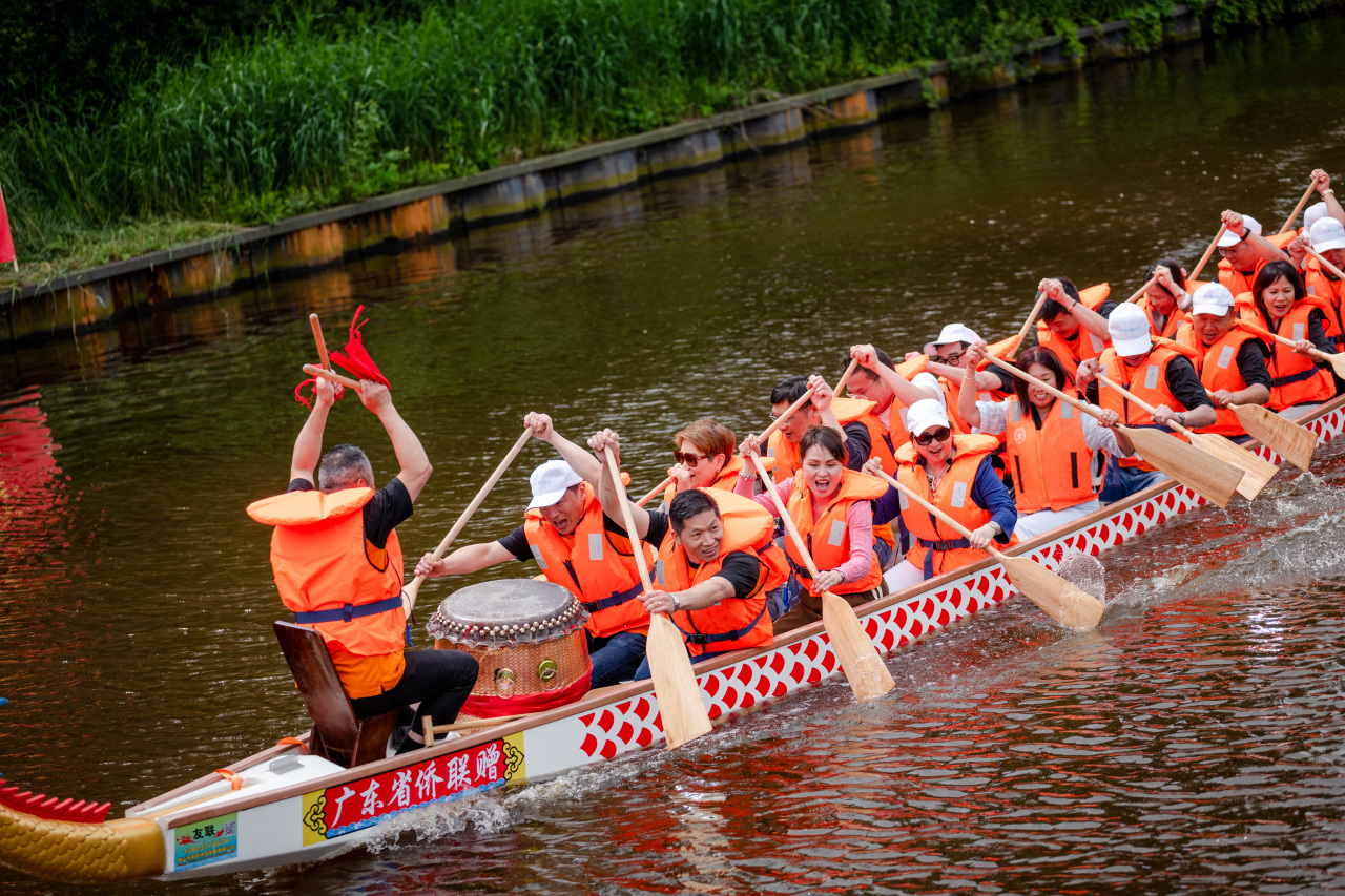 荷兰华人乘坐广东省侨联赠送的龙舟，体验划龙舟的乐趣。（全荷华人社团联合会 供图）