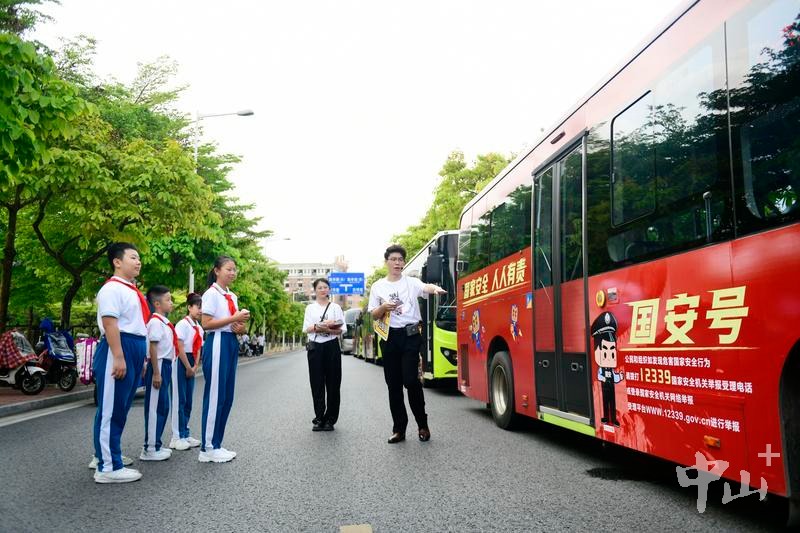 工作人员向学生介绍“国安号”公交车。 记者 余兆宇 摄