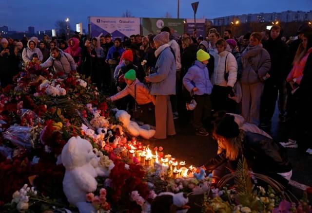 ▲2023年3月23日，俄罗斯莫斯科近郊，人们在恐袭事件发生地附近摆放鲜花和蜡烛悼念遇难者 图/新华社