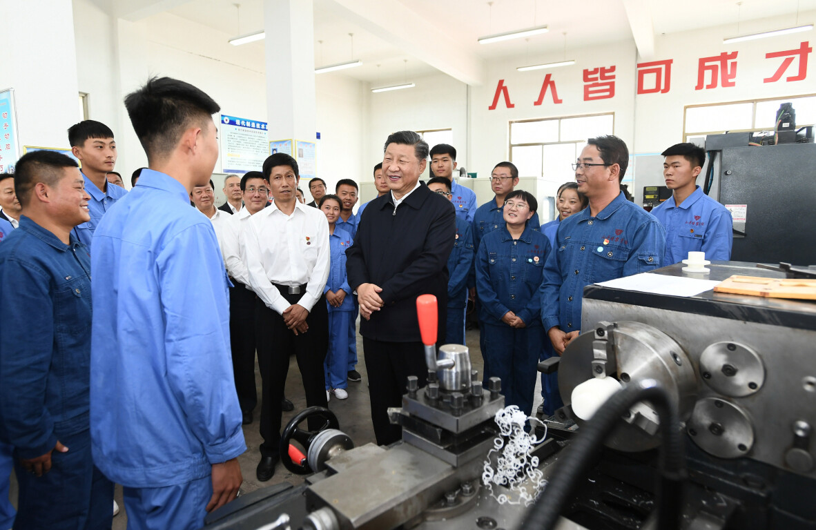 2019年8月20日，习近平总书记在甘肃省张掖市山丹培黎学校现代制造技术实训室，观看职业技能实训，同师生亲切交流。