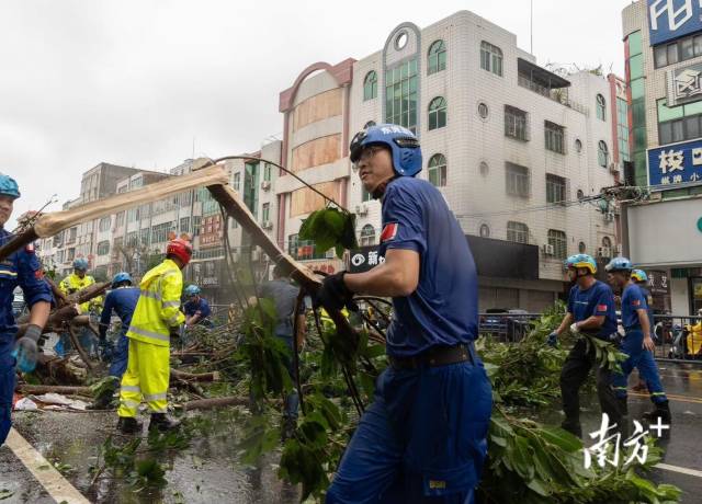 9月7日，湛江市徐闻县，蓝天救援队见路上有树木、栏杆挡路，众人纷纷下车合力抬起路障。