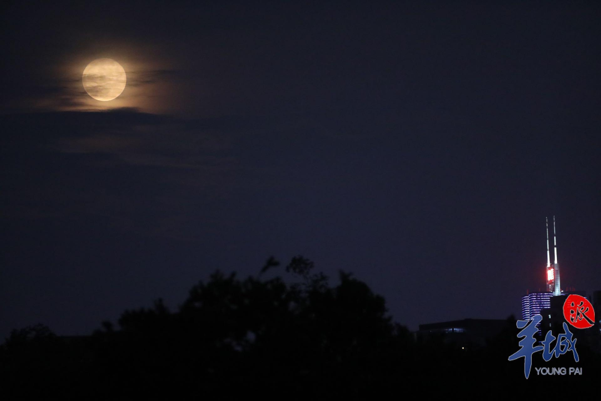 资料图：月亮透过云层出现在广州夜空。羊城晚报全媒体记者 梁怿韬 摄