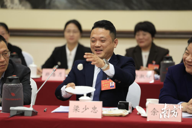 省人大代表、汕头市晶华食品有限公司总经理梁少忠现场拿鱼丸“打乒乓球”。