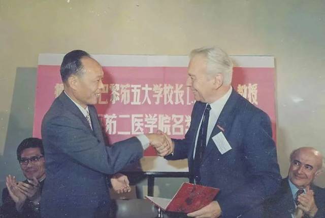 上海第二医学院（现上海交通大学医学院）校长王振义（前左）授予法国巴黎第五大学校长欧基埃名誉教授称号（摄于1985年）。新华社发（上海交通大学医学院供图）