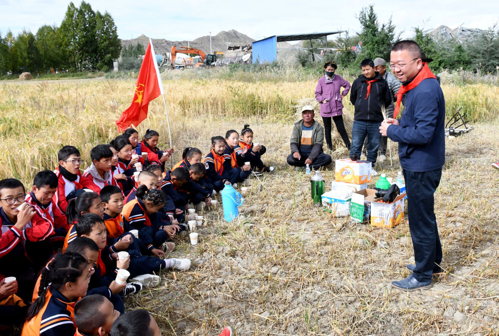 上海援藏教师潘杰（右一）带领学生在青稞地里上思政课（2021年9月14日摄）。新华社发