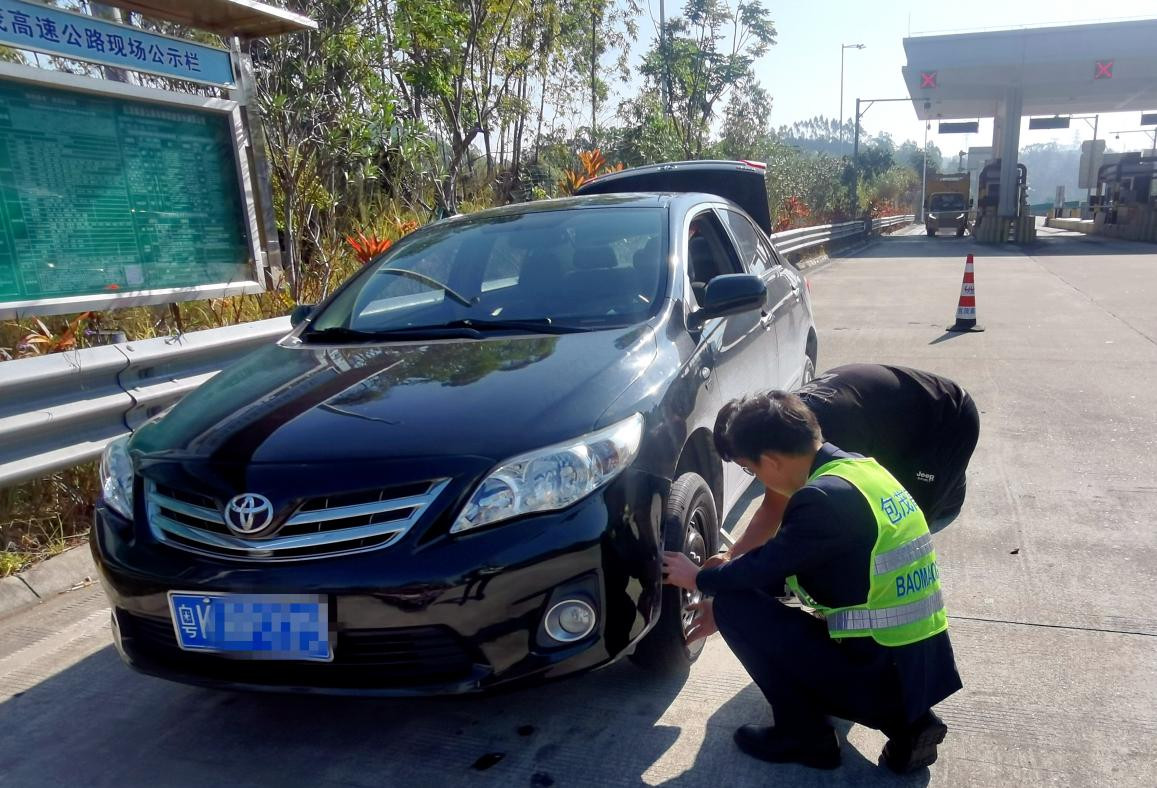 包茂高速东岸站出口,工作人员赵孟可帮助小车司机更换爆胎,解决出行烦恼。