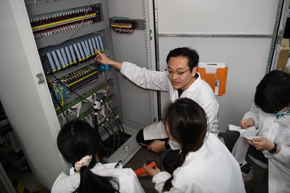 　　2024年4月6日，在位于安徽合肥的中国科学技术大学，安徽省先进功能高分子薄膜工程实验室团队成员在检修自主研制的高分子薄膜原位双向拉伸实验设备的电气控制系统。
