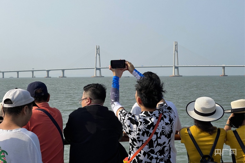 “大湾区一号”微游轮上的游客正在拍摄前方的港珠澳大桥（央广网记者 官文清 摄）
