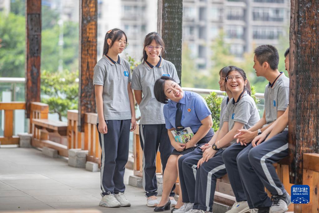 9月20日，在重庆市第三十七中学，梅玫与学生在课间交流。新华社记者 黄伟 摄