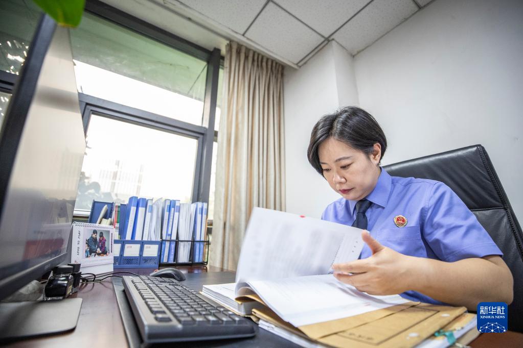 9月20日，在重庆市大渡口区人民检察院，梅玫在办公室内查阅最近侦办未成年案件的卷宗。新华社记者 黄伟 摄