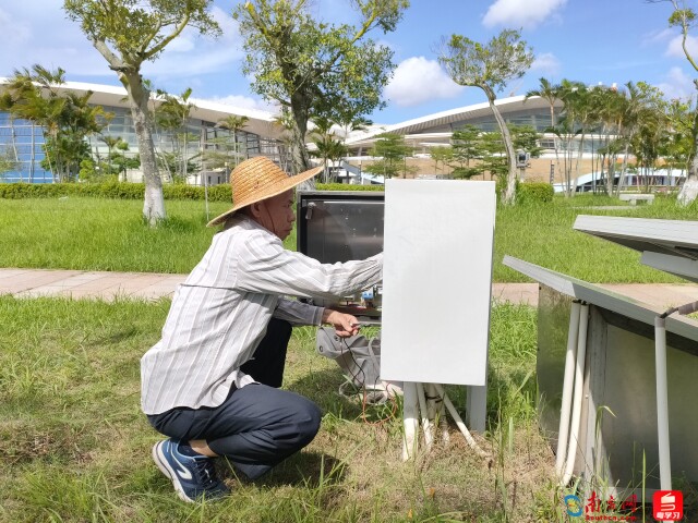 湛江市气象局工作人员台风前巡检奥体中心体育馆外的自动气象站。 黄燕娣摄影