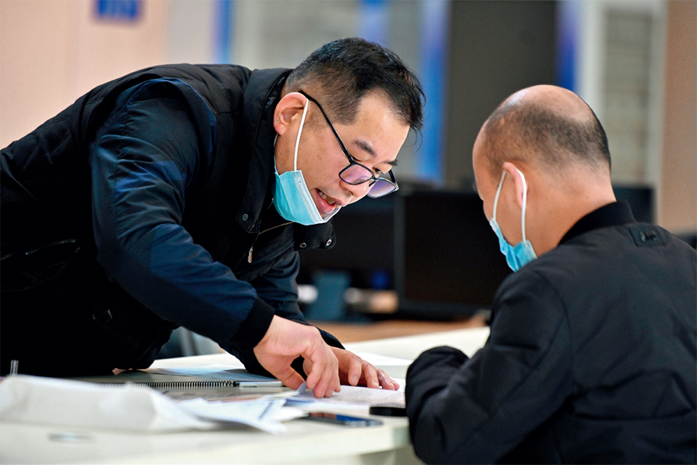在福建省福州市马尾区政务服务中心，工作人员在前台为市民办理业务（2023年2月21日摄）周义摄 / 《瞭望》