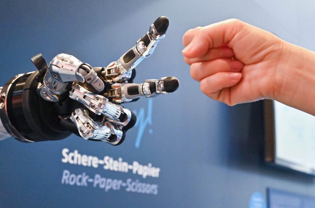 　　4月23日，在德国汉诺威工博会上，参观者与一款智能机器人进行“石头剪子布”游戏。新华社记者任鹏飞摄