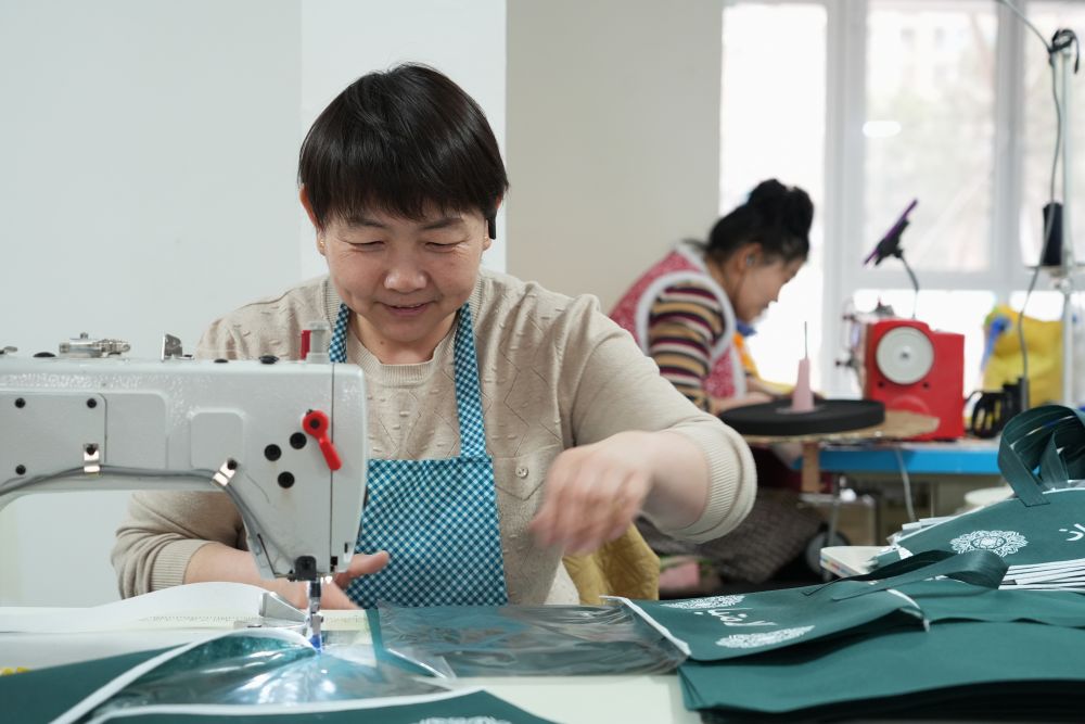 2025年3月27日，回迁居民在雄安新区“雄业创工坊”包装工坊加工无纺布。工坊引入有持续发展潜力、对社区环境影响较小的产业，为回迁群众提供灵活多样的就业岗位，让回迁居民实现“上楼安家，下楼就业”。