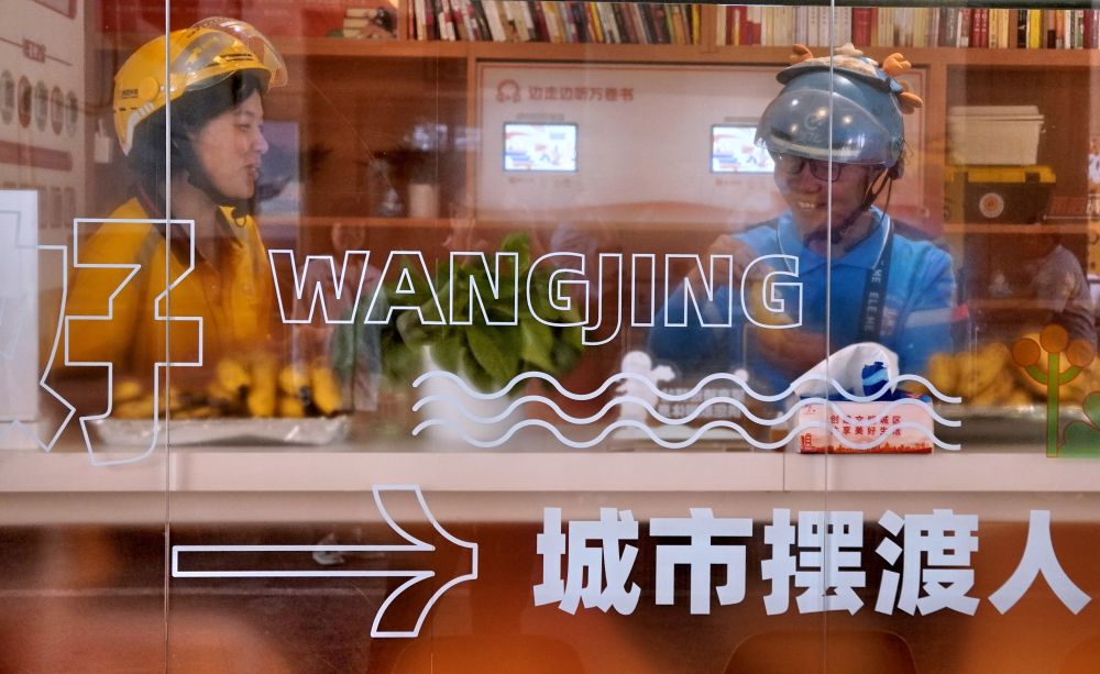 2024年5月9日，两名骑手在北京市朝阳区一所智能化工会驿站里休息。驿站为快递员等劳动者提供免费饮用水、常用应急药品，还与音像出版机构、图书馆合作，为劳动者提供免费图书阅读等服务。
