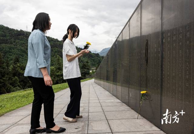 2023年5月7日，13岁的邓琪倩和妈妈李秀华来到“5·12”特大地震遇难者公墓，在擦去姐姐名字上的灰尘后，她摆上了一支鲜花。