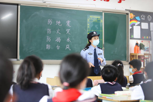 一位民警在给学生讲解防灾减灾知识。图源：新华社