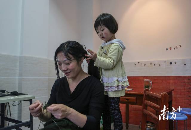 邓琪倩从小就喜欢黏着李秀华，特别喜欢给妈妈扎头发。摄于2013年5月。