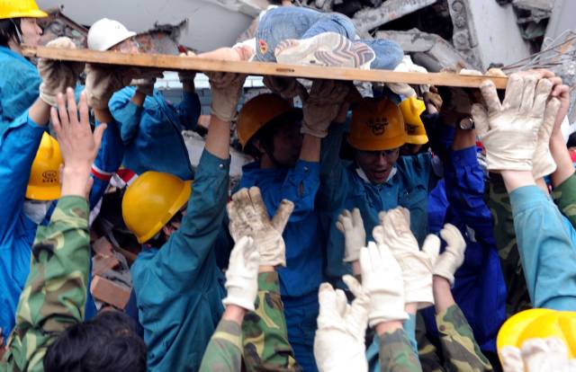 　　2008年5月13日，在中国四川绵竹市汉旺镇一所中学内，救援人员经过十几个小时的艰苦努力，终于从废墟中救出一位女学生。图源：新华社