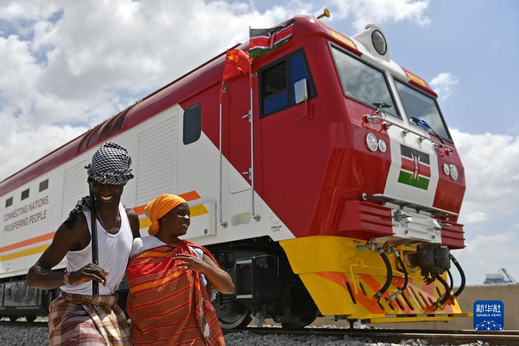 在肯尼亚蒙巴萨，当地民众在中国承制的蒙内铁路首批内燃机车旁载歌载舞（2017年1月11日摄）。新华社记者 孙瑞博 摄