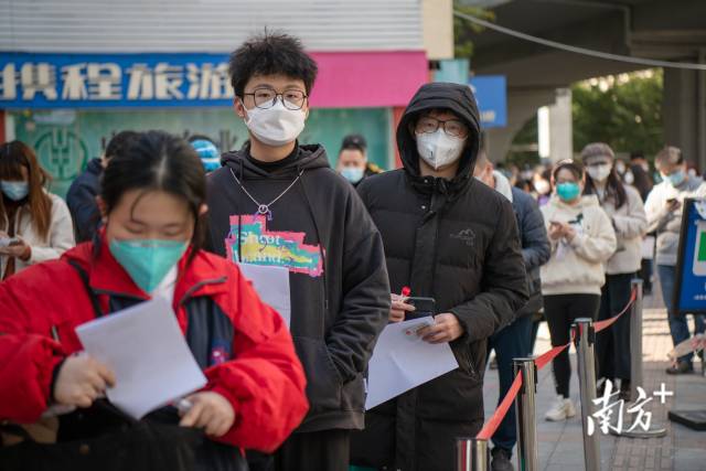 广州市东山口地铁口F口核酸检测采样点现场，考生排队检测核酸。