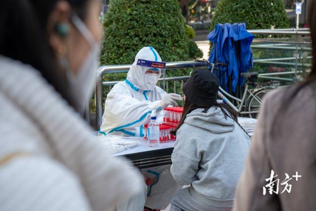 广州市东山口地铁口F口核酸检测采样点现场，考生排队检测核酸。 