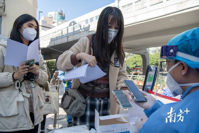 广州市东山口地铁口F口核酸检测采样点现场，考生排队检测核酸。