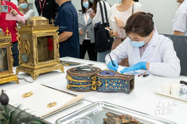 在广东省文物保护科技中心，广东省博物馆无机组修复师在对广钟进行珐琅修复。