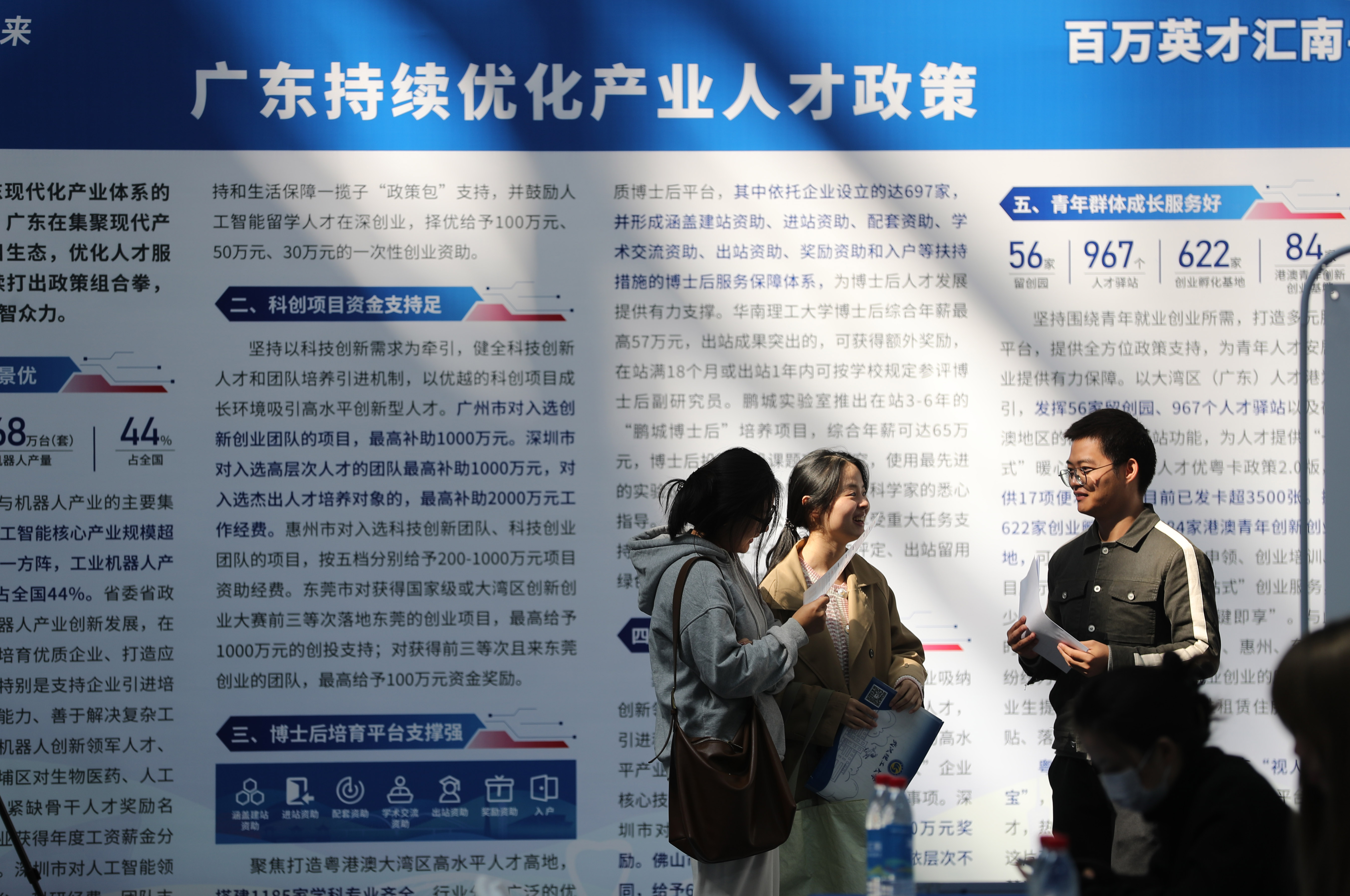 2025年10月23日,“百万英才汇南粤-NEP1_20251023_C0028831309 学生在广东省人才政策宣传栏前交流。