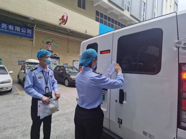 监管人员检查场馆配餐用车相关标签,并为车辆贴封条。