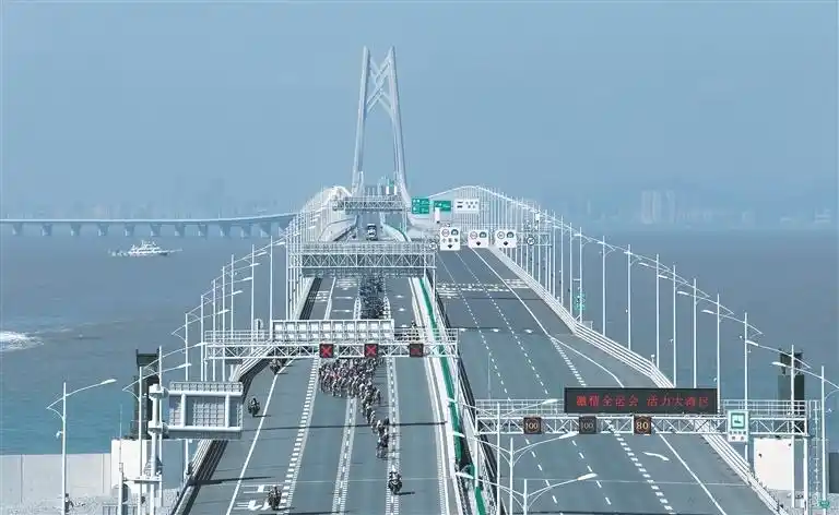 11月8日，第十五届全国运动会公路自行车男子个人赛参赛选手在港珠澳大桥上骑行。新华社发