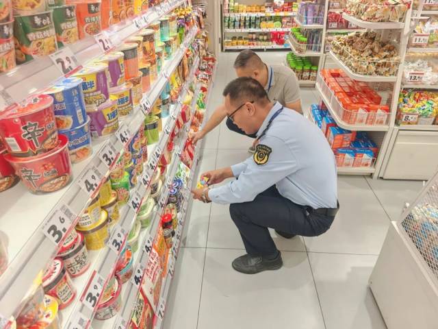 监管人员对接待酒店周边食品经营单位进行巡查。