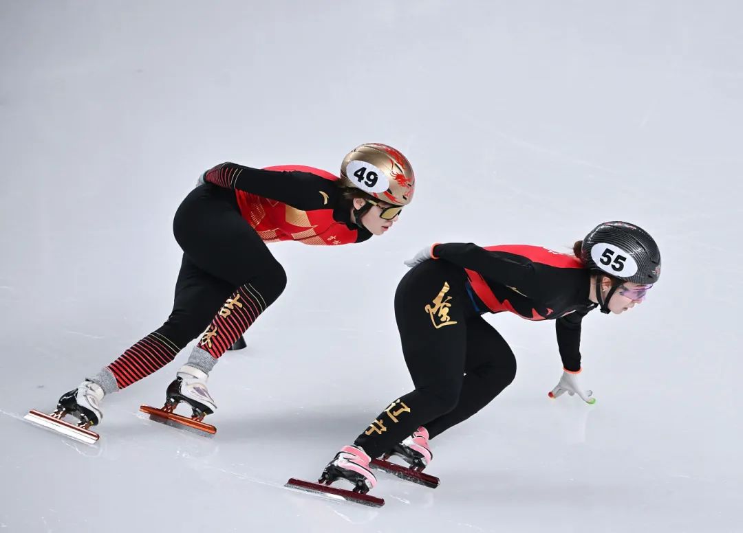 18日，广东张楚桐（左）在短道速滑公开组女子1000米比赛中