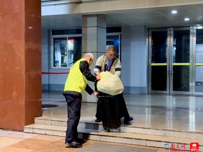 车站志愿者帮助老年乘客搬运行李