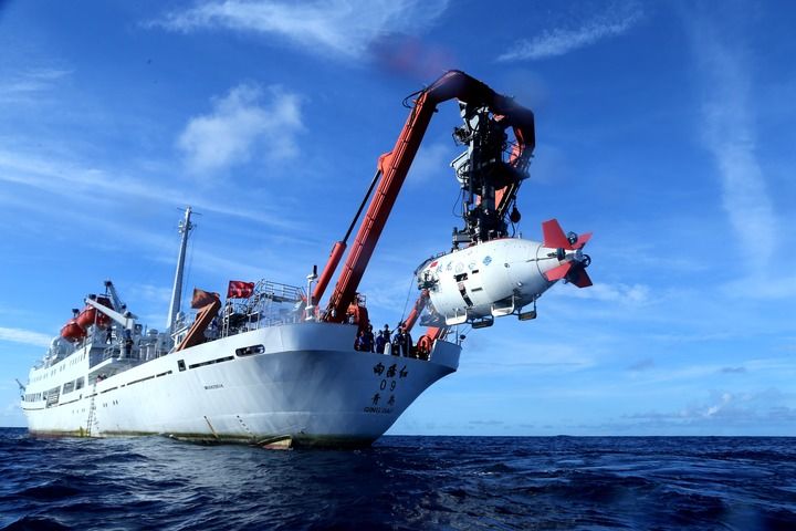 在西太平洋海域，“蛟龙”号载人潜水器离开“向阳红09”科学考察船准备进入水中，进行中国大洋38航次最后一潜（2017年6月13日摄）。新华社记者 刘诗平 摄