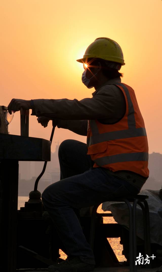4月12日，武汉江滩的工地上，一名工人迎着夕阳加紧工作，抢回工期。