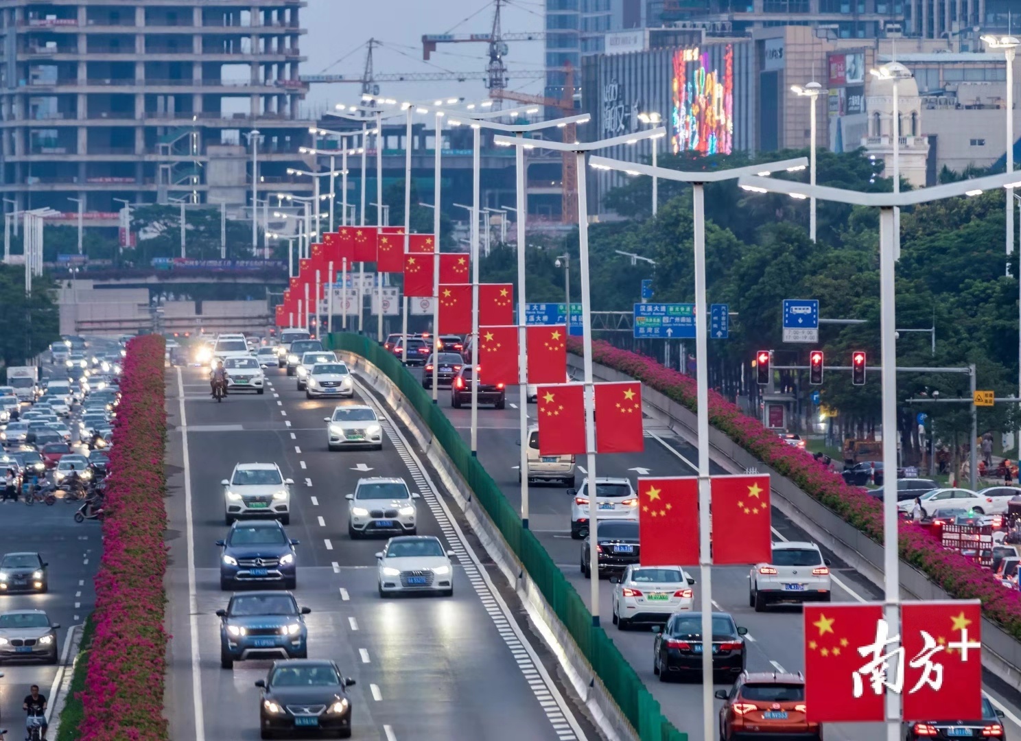 广州一立交桥路中间的灯杆上悬挂着国旗。