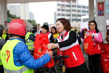 春运首日全国人大代表米雪梅做志愿者派发“福袋”，寄语“返乡铁骑”