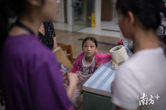 6月11日，广东省第二人民医院内，思莹皱着眉听大人们讲她的病情。
