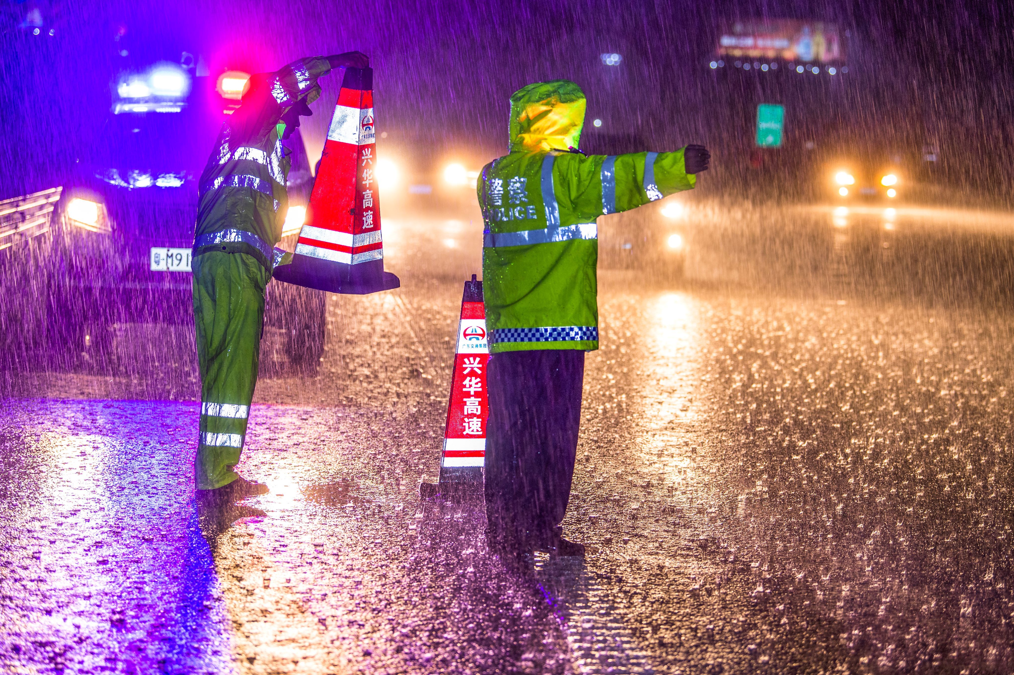 梅州公安交警冒雨在济广高速梅州五华樟树塘立交疏导车流。（摄影：何志林）  