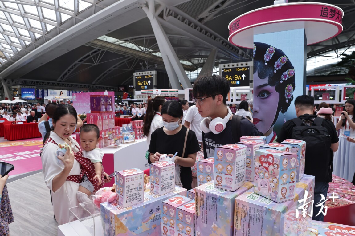 广州南站十五运会和残特奥会官方特许商品零售店吸引了不少旅客驻足。