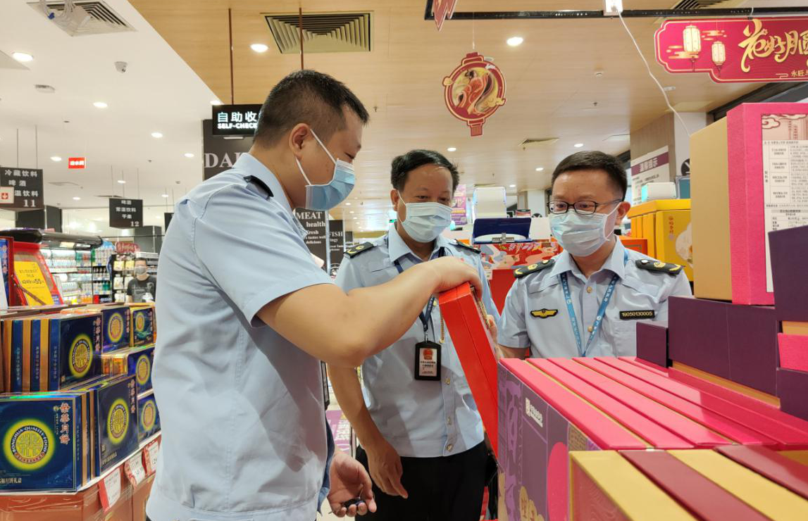 执法人员在超市月饼销售区，对月饼售价、混搭销售等情况进行检查